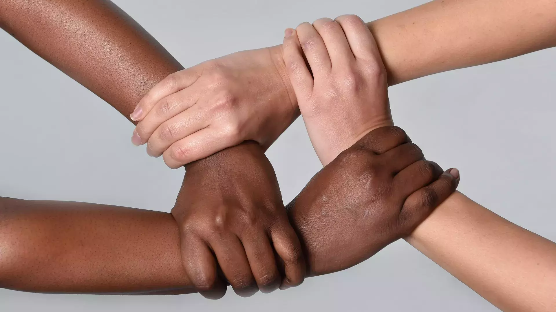 4 mains jointes pour former une chaîne de solidarité